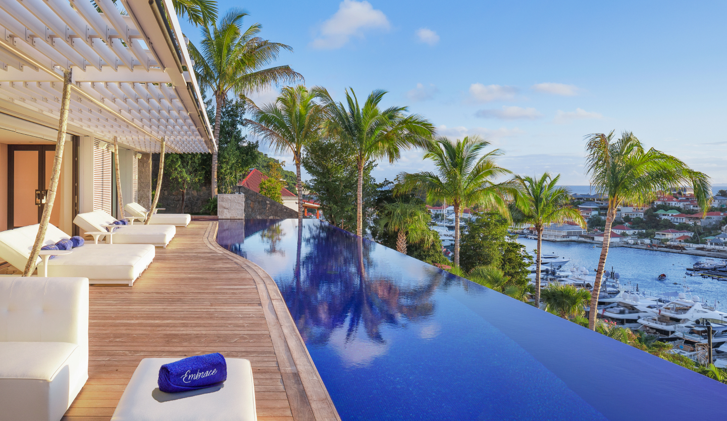 Villa Embrace infinity pool terrace at golden hour overlooking Gustavia harbour